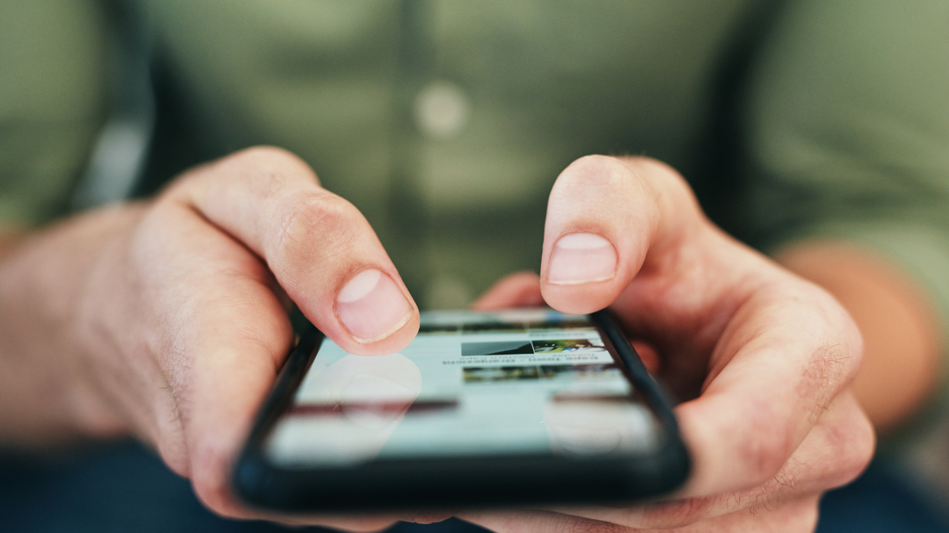 a close-up of an unrecognizable man holding a cell phone